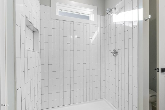 bathroom with toilet and tiled shower