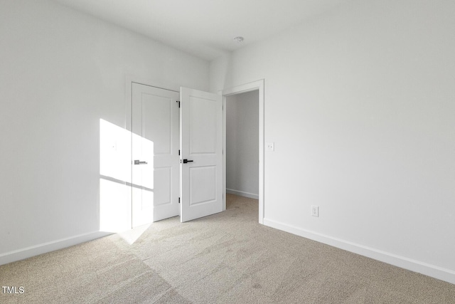 spare room featuring light colored carpet