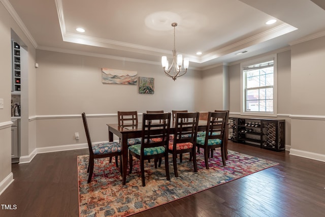 dining room featuring ornamental molding, a tray ceiling, dark wood-type flooring, and a notable chandelier