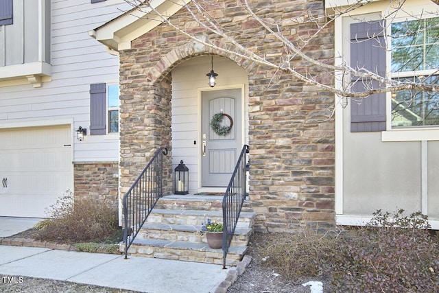 view of exterior entry with a garage and stone siding