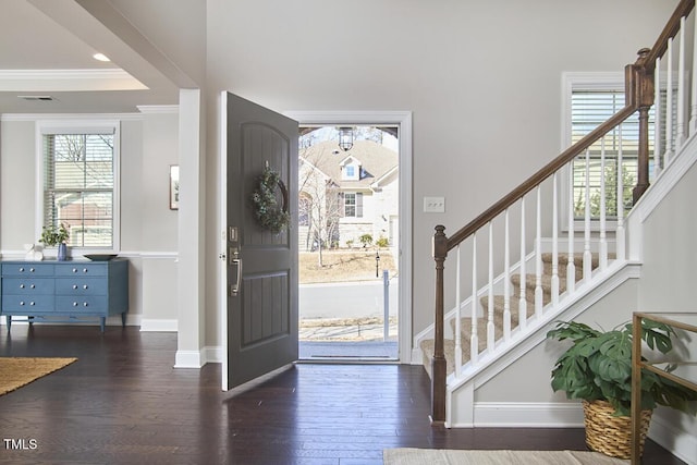 foyer entrance with crown molding, stairs, baseboards, and dark wood-style flooring