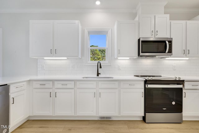 kitchen featuring white cabinets, light wood-type flooring, stainless steel appliances, and sink