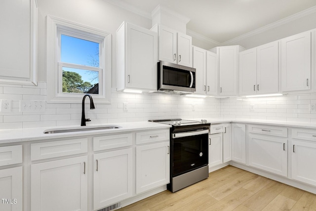 kitchen with sink, white cabinets, and appliances with stainless steel finishes