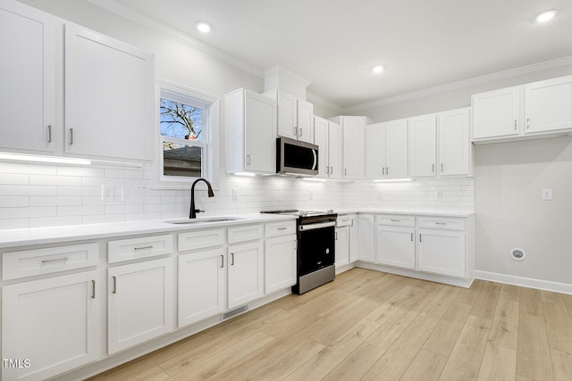 kitchen featuring crown molding, sink, appliances with stainless steel finishes, light hardwood / wood-style floors, and white cabinetry