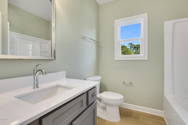 bathroom with hardwood / wood-style floors, vanity, and toilet