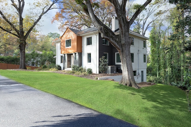 view of front of property featuring a front lawn and cooling unit