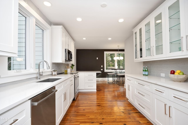 kitchen with pendant lighting, dark wood-type flooring, white cabinets, and stainless steel appliances