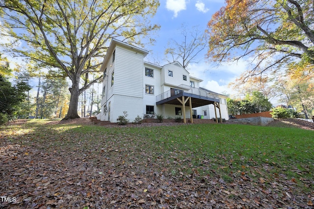 back of property featuring a yard and a wooden deck