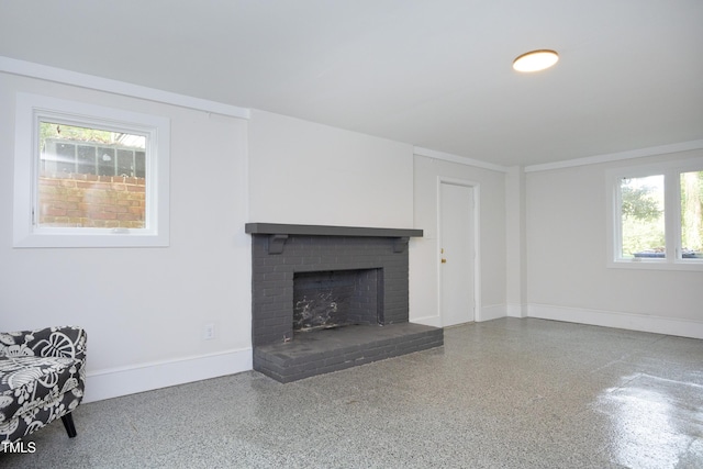 unfurnished living room featuring a healthy amount of sunlight and a fireplace