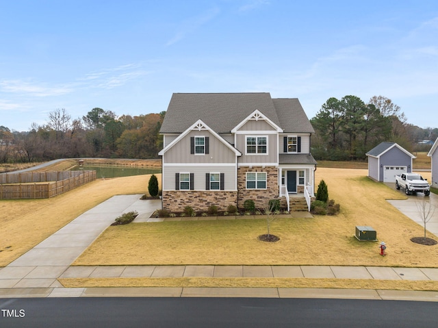 craftsman house with a garage, an outbuilding, and a front yard