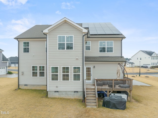 rear view of house with a yard, solar panels, and a deck