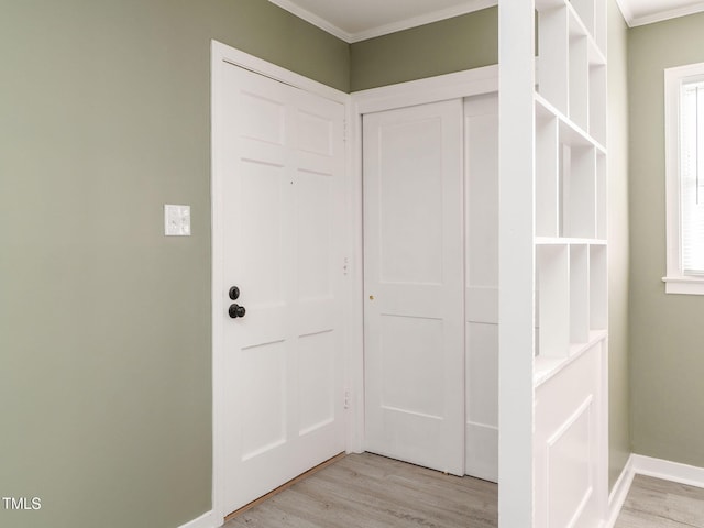 corridor featuring light wood-type flooring and ornamental molding