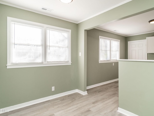 unfurnished room with ornamental molding, a healthy amount of sunlight, and light hardwood / wood-style floors