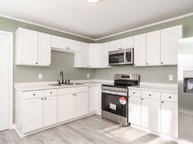 kitchen with appliances with stainless steel finishes, crown molding, and sink