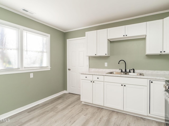 kitchen featuring white cabinets, light hardwood / wood-style floors, crown molding, and sink