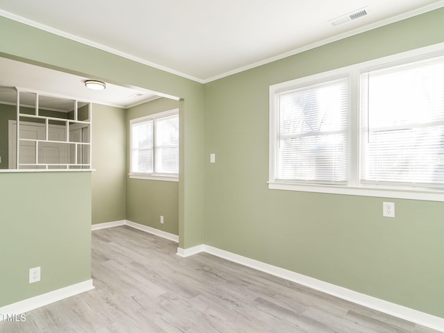 empty room featuring crown molding and light wood-type flooring