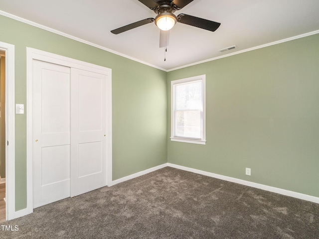 unfurnished bedroom featuring dark colored carpet, ceiling fan, ornamental molding, and a closet