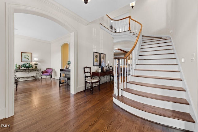 entryway featuring crown molding and dark wood-type flooring