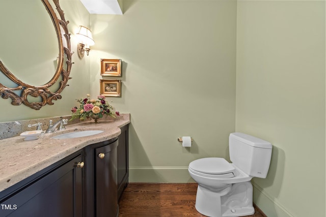 bathroom featuring toilet, wood-type flooring, and vanity