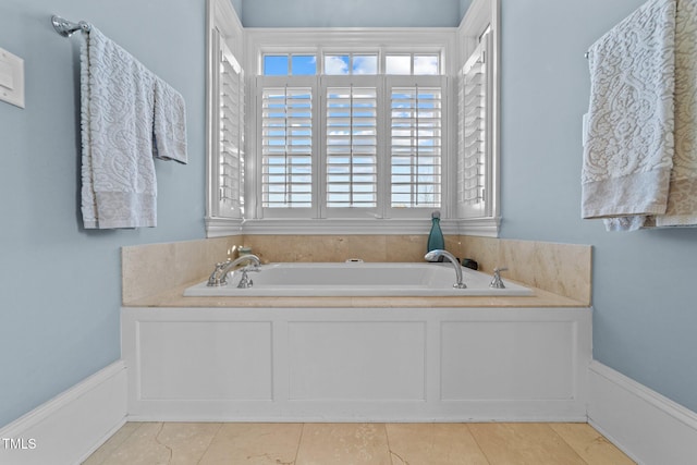 bathroom with a tub to relax in and tile patterned floors