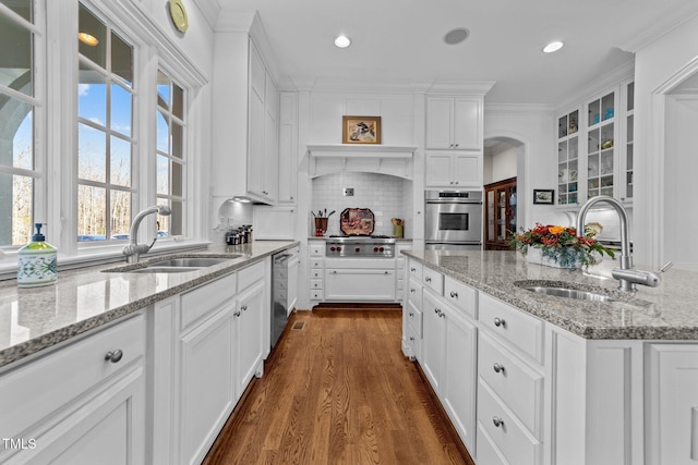 kitchen with sink, dark hardwood / wood-style flooring, backsplash, and light stone countertops