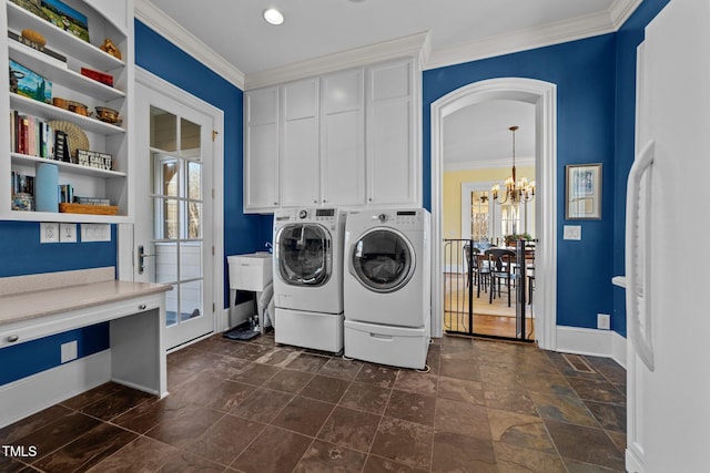 laundry room featuring a notable chandelier, cabinets, crown molding, and washing machine and clothes dryer