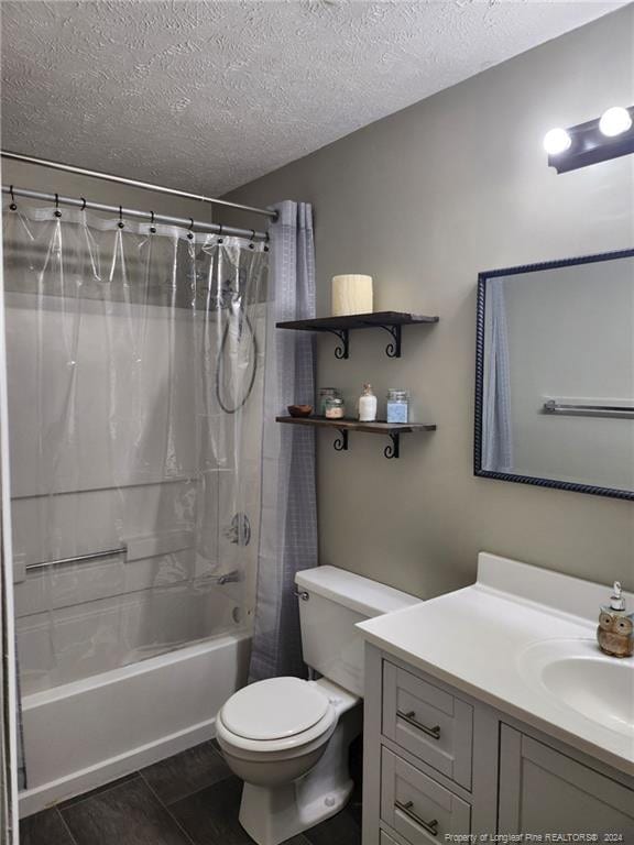 full bathroom featuring tile patterned flooring, a textured ceiling, toilet, shower / bath combo with shower curtain, and vanity