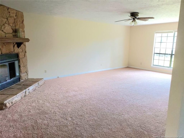 unfurnished living room with a textured ceiling, ceiling fan, carpet floors, and a fireplace