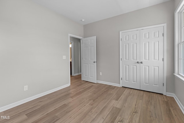 unfurnished bedroom with a closet and light hardwood / wood-style flooring