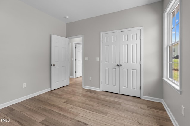 unfurnished bedroom featuring a closet and light hardwood / wood-style flooring