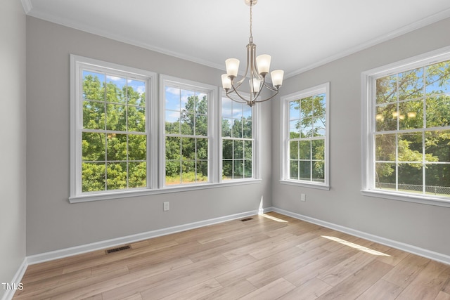 unfurnished dining area featuring light hardwood / wood-style floors, ornamental molding, and a wealth of natural light