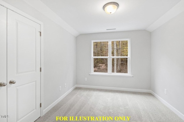 empty room with vaulted ceiling and light colored carpet