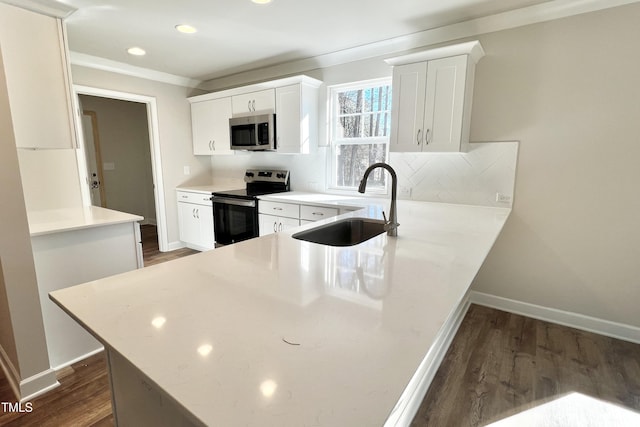 kitchen with sink, white cabinetry, stainless steel appliances, dark hardwood / wood-style flooring, and kitchen peninsula