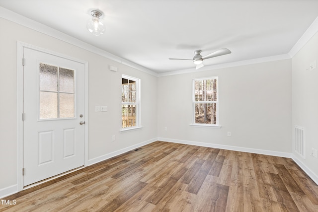 spare room featuring ornamental molding, wood finished floors, visible vents, and baseboards