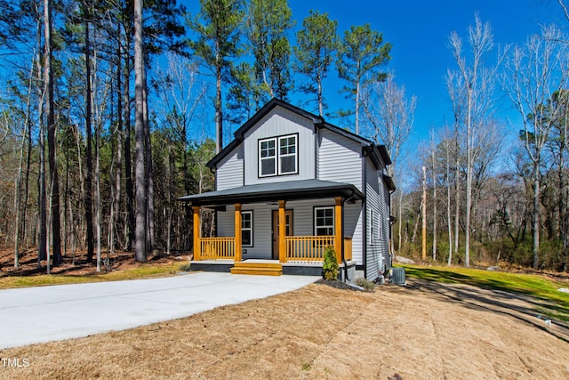 view of front of house featuring board and batten siding, covered porch, central AC, and driveway