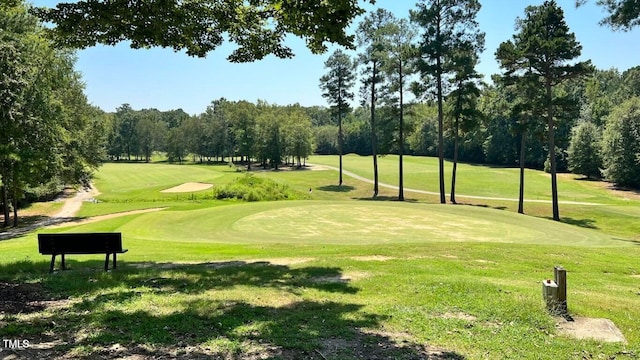 view of property's community with view of golf course and a lawn