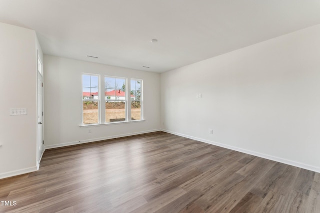 unfurnished room with baseboards and wood finished floors