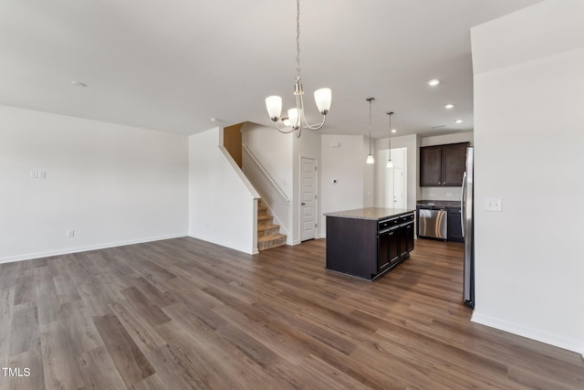 kitchen with open floor plan, stainless steel appliances, a kitchen island, and dark wood-style floors