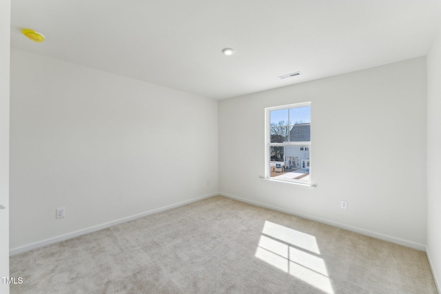 unfurnished room featuring carpet floors, baseboards, and visible vents