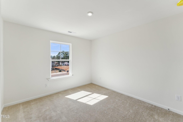 unfurnished room featuring carpet, visible vents, and baseboards