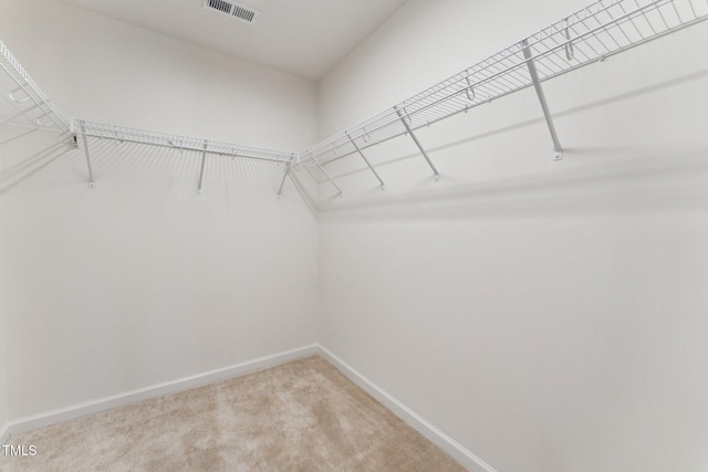 spacious closet with light colored carpet and visible vents