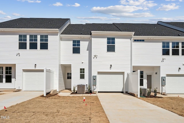 townhome / multi-family property featuring a garage, central AC, and driveway