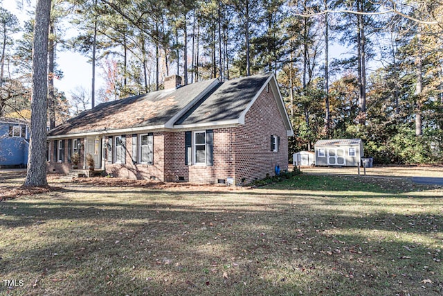 view of front of property with a shed and a front lawn