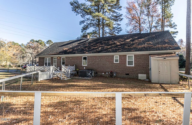 rear view of property with a shed, cooling unit, and a deck