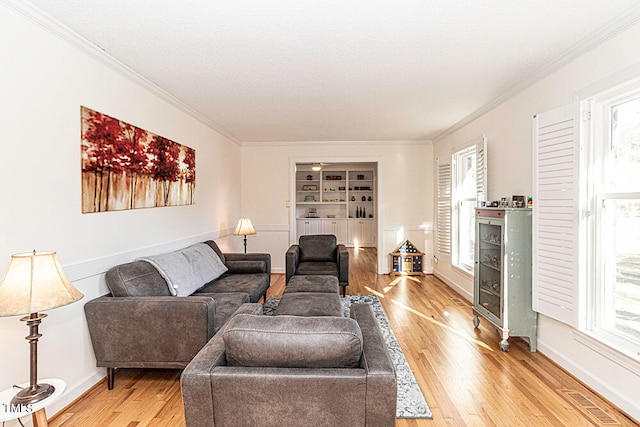 living room featuring a healthy amount of sunlight, wood-type flooring, and ornamental molding