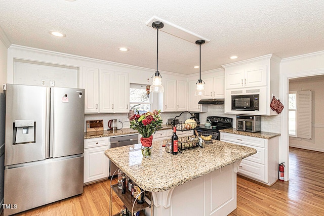 kitchen featuring black appliances, a center island, a healthy amount of sunlight, and light hardwood / wood-style floors