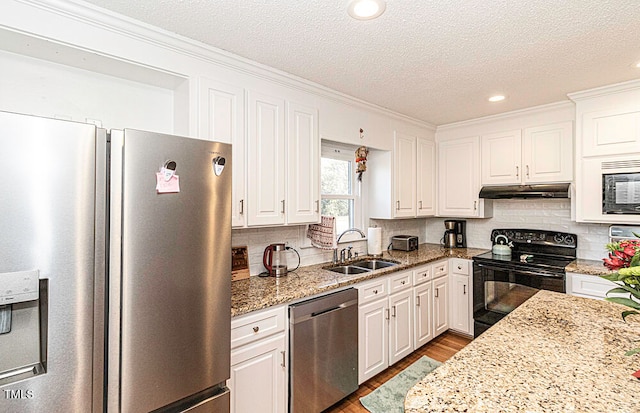 kitchen with sink, light stone counters, white cabinetry, and black appliances