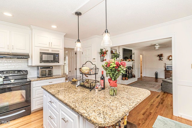 kitchen with white cabinetry, a center island, black appliances, and light wood-type flooring