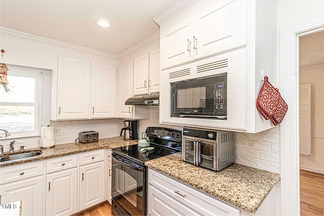 kitchen featuring white cabinetry, light hardwood / wood-style flooring, and black appliances