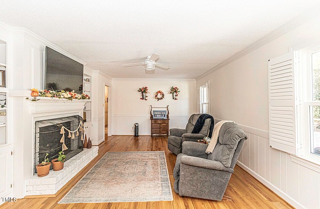 living room featuring a fireplace, hardwood / wood-style floors, a textured ceiling, and a healthy amount of sunlight